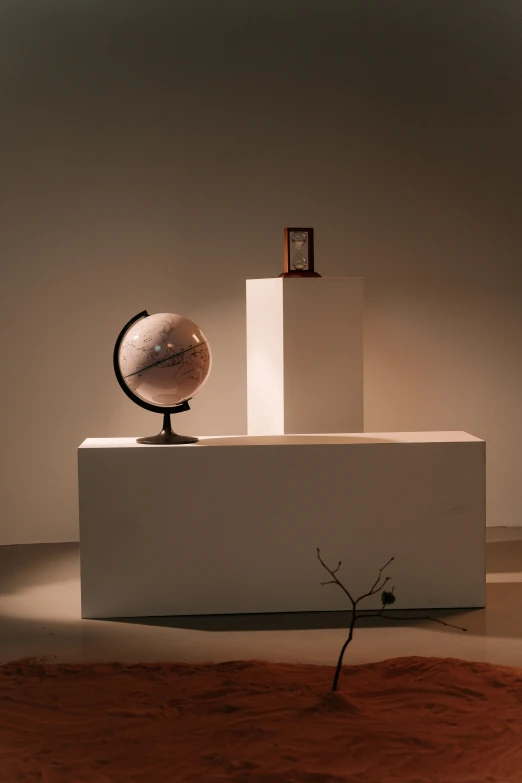 a globe sitting on top of a white pedestal, backside of scenography elements, curated collections, brown, moody setting