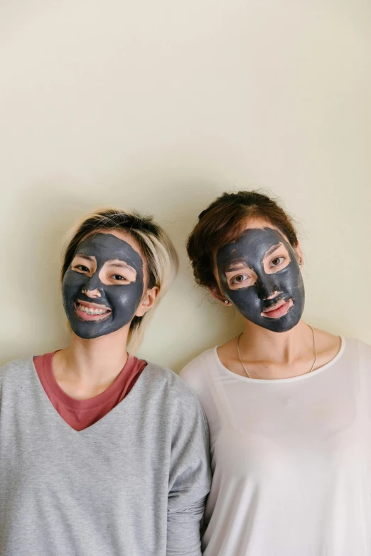 two women standing next to each other with facial masks on their faces, trending on pexels, mingei, charcoal color skin, japanese collection product, 64x64, mole on cheek