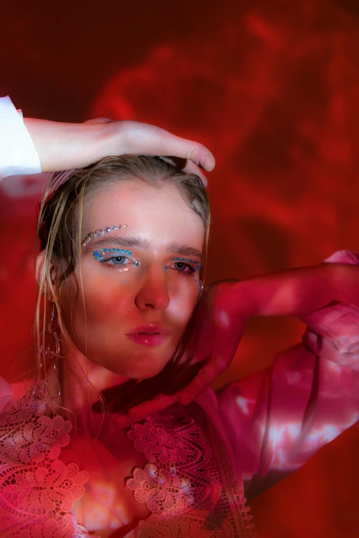 a close up of a person holding a nintendo wii controller, an album cover, by Ignacy Witkiewicz, magic realism, cover with a lot of red water, grim fashion model looking up, julia hetta, red lighting on their faces