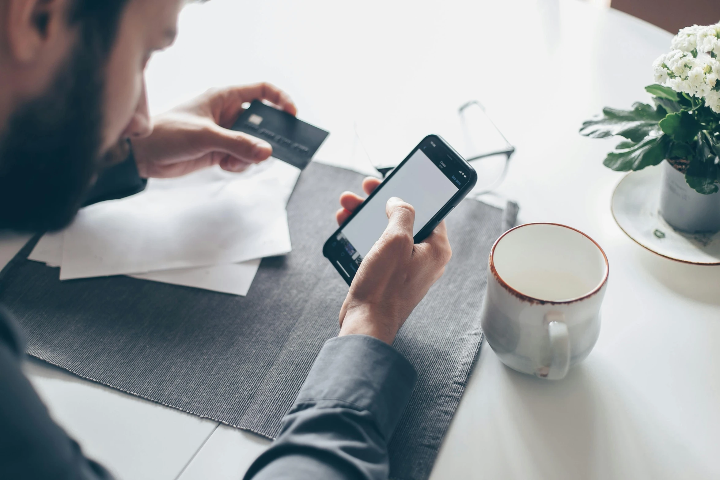 a man holding a credit card while sitting at a table, by Adam Marczyński, pexels contest winner, private press, corporate phone app icon, uk, checking her phone, avatar image