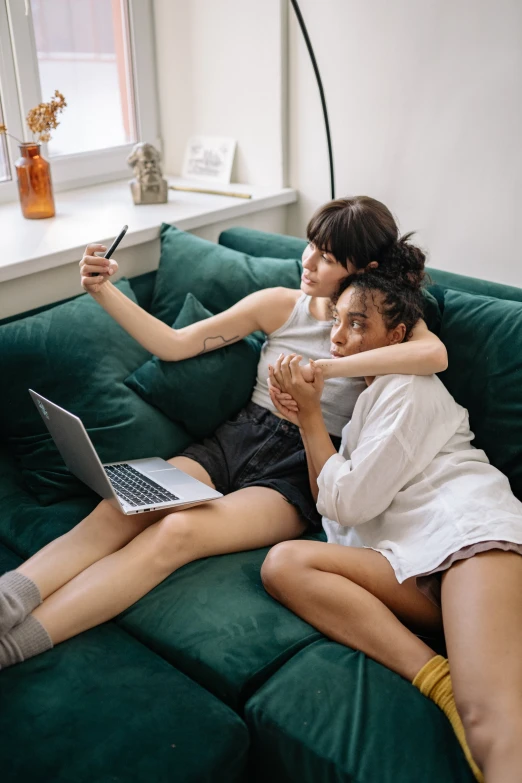 a couple of women sitting on top of a green couch, a picture, trending on pexels, happening, bad selfie, webcam, lesbian, everything fits on the screen