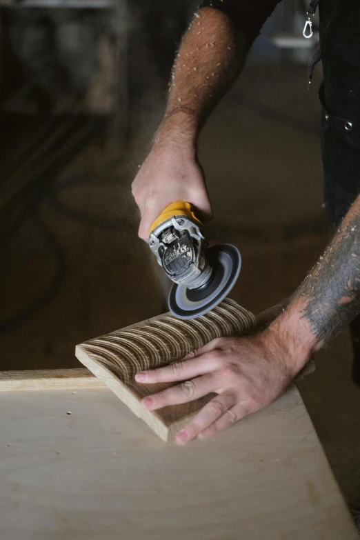 a man sanding a piece of wood with a machine, a stipple, trending on pexels, renaissance, floating spiral sand, australian, curvy build, corduroy