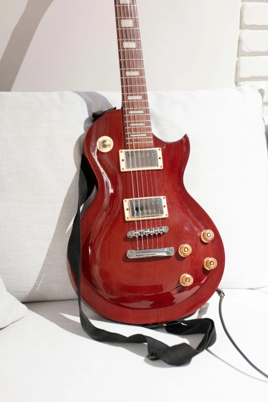 a red guitar sitting on top of a white couch, profile image, ecommerce photograph, detailed product image, front facing shot