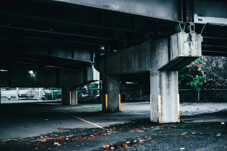 a parking garage filled with lots of parking space, unsplash, brutalism, sitting under bridge, discovered photo, iron and asphalt, flattened