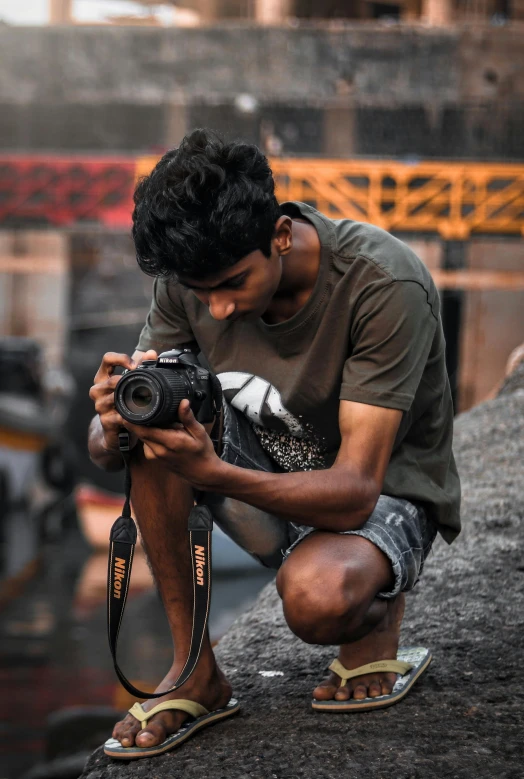 a man squatting down while holding a camera, by Max Dauthendey, pexels contest winner, jayison devadas, working, rugged, profile pic