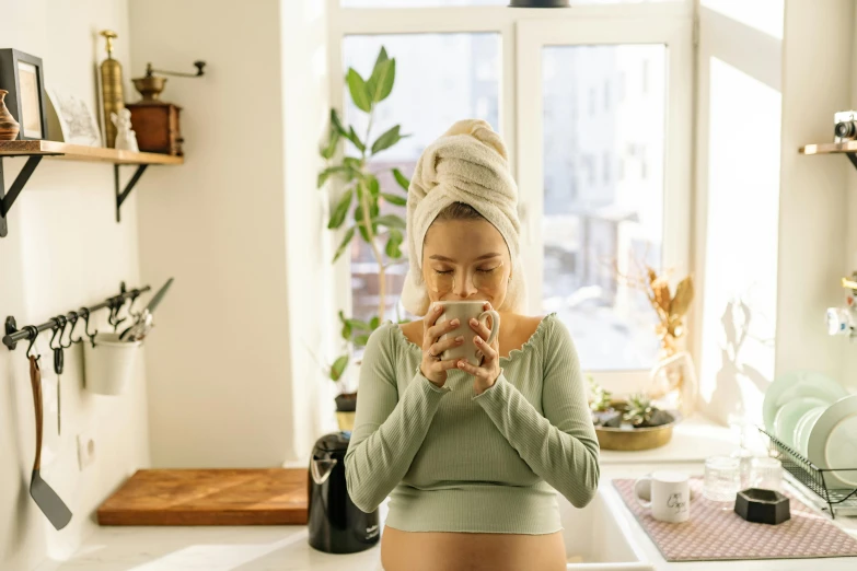 a pregnant woman taking a selfie in the kitchen, inspired by Elsa Bleda, trending on pexels, happening, green tea, belly button showing, gif, winter season