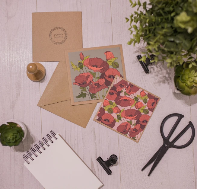 a bunch of cards sitting on top of a table, a still life, inspired by Eden Box, featured on instagram, private press, poppies, on a wooden desk, crimson themed, writing a letter