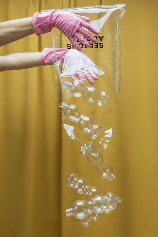 a person in pink gloves holding a plastic bag, inspired by Lynda Benglis, reddit, floating bubbles, detailed product shot, hanging upside down, many cryogenic pods