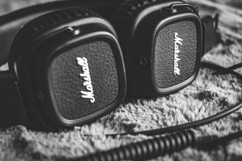 a pair of headphones sitting on top of a blanket, by Adam Marczyński, pexels, photorealism, electric guitars, closeup!!!!!!, black ears, leather padding