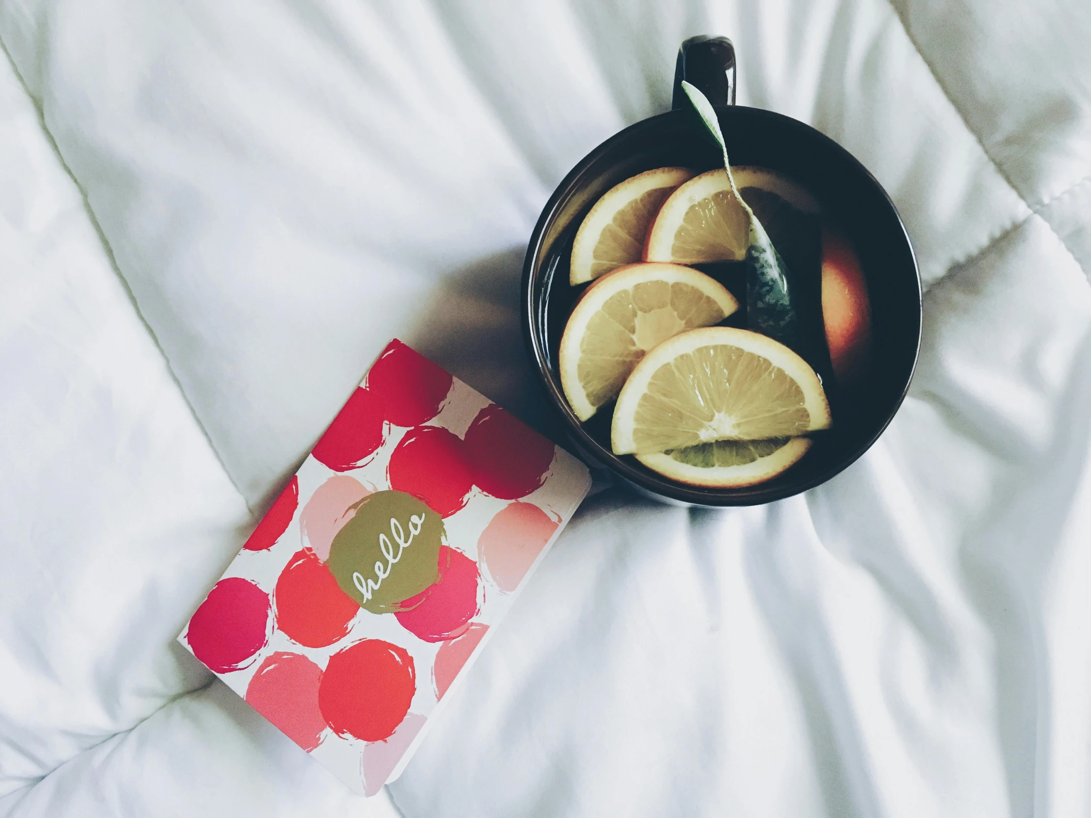 a book sitting on top of a bed next to a bowl of fruit, teapot, lemonade, thumbnail, scrapbook