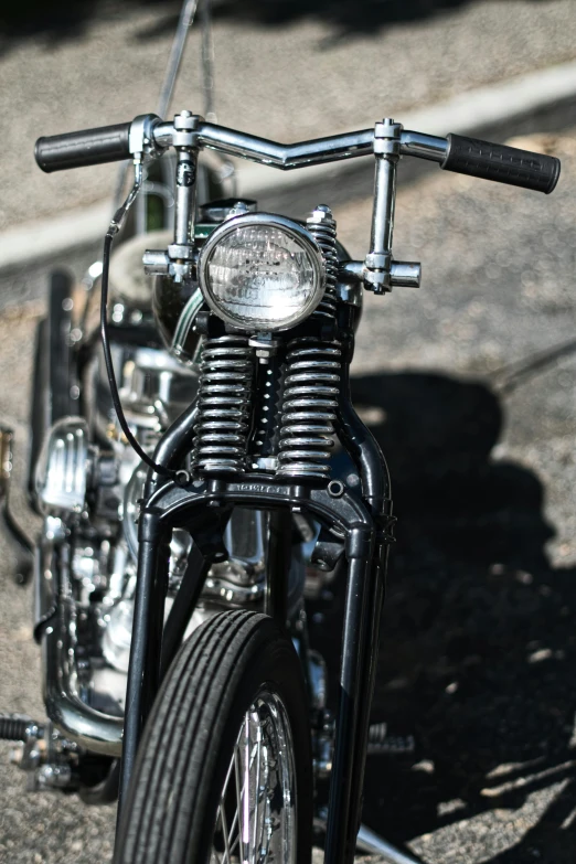 a close up of a motorcycle parked on a street, on display, in the sun, front lighting, intricate mechanical details