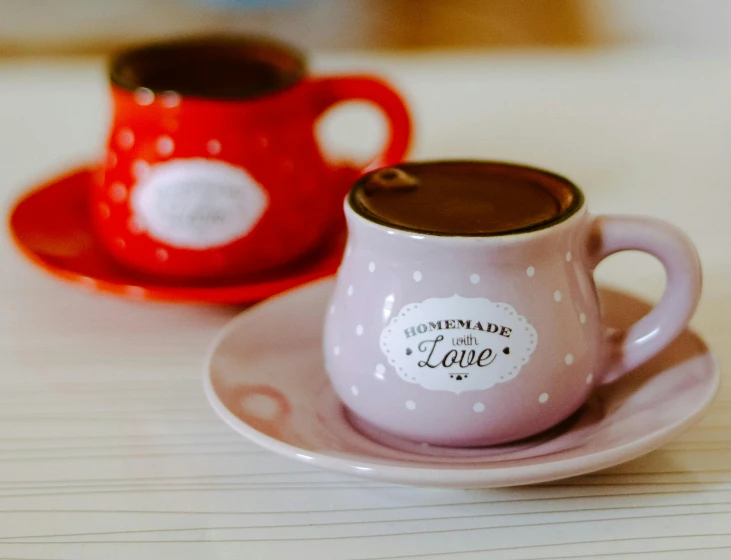 a couple of coffee cups sitting on top of a table, inspired by Valentine Hugo, trending on pexels, brown and pink color scheme, polka dot, engraved, pottery