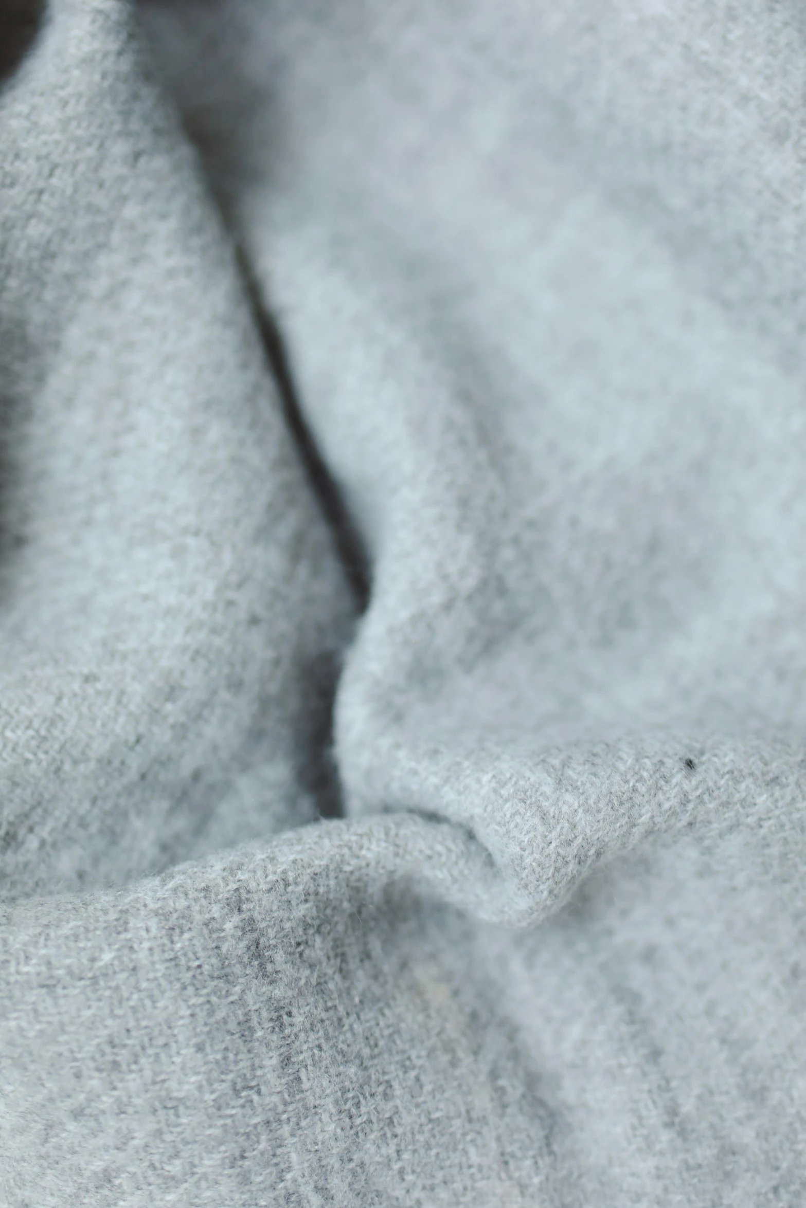 a cat laying on top of a bed covered in a blanket, inspired by Toss Woollaston, trending on reddit, seamless micro detail, light grey mist, detailed product image, detail shot