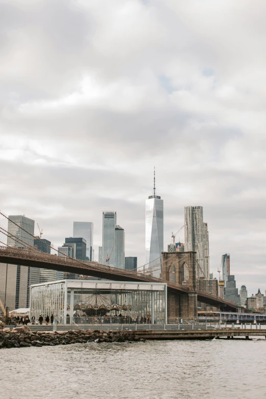 a bridge over a body of water with a city in the background, by Nina Hamnett, trending on unsplash, new - york skyline in winter, frank gehry, a blond, shot on sony a 7