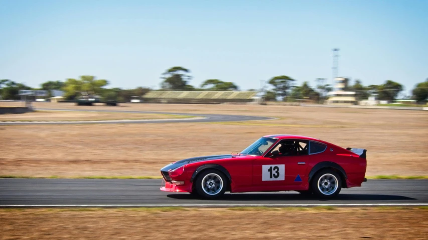 a red sports car driving on a race track, a portrait, by Peter Churcher, unsplash, soft rim light, kirokaze and paul robertson, panoramic shot, old school fpr