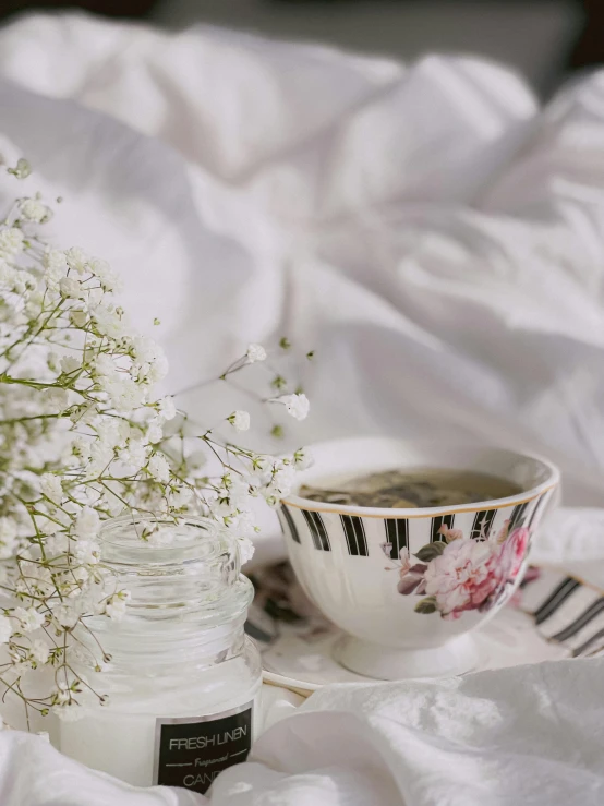 a cup of coffee and some flowers on a bed, by Lucia Peka, trending on unsplash, rococo, gypsophila, low quality photo, half image