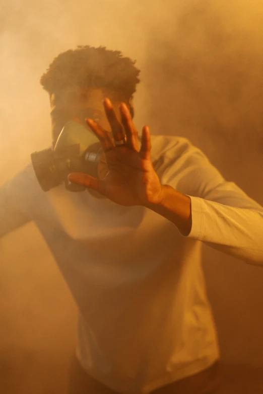 a man wearing a gas mask in a smoke filled room, afrofuturism, hands shielding face, production photo, ((mist)), 2 1 savage