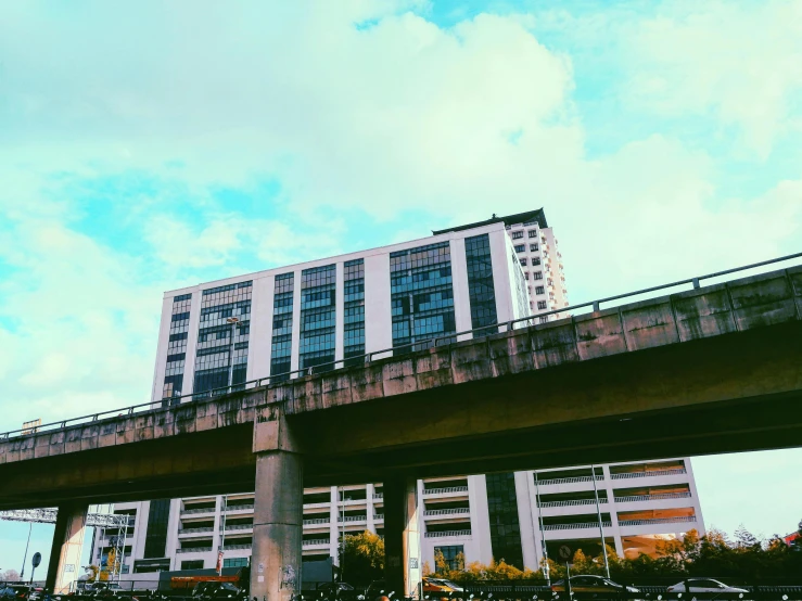 a train traveling over a bridge next to tall buildings, by Washington Allston, unsplash, brutalism, bangkok townsquare, instagram story, low angle facing sky, 2 0 0 0's photo