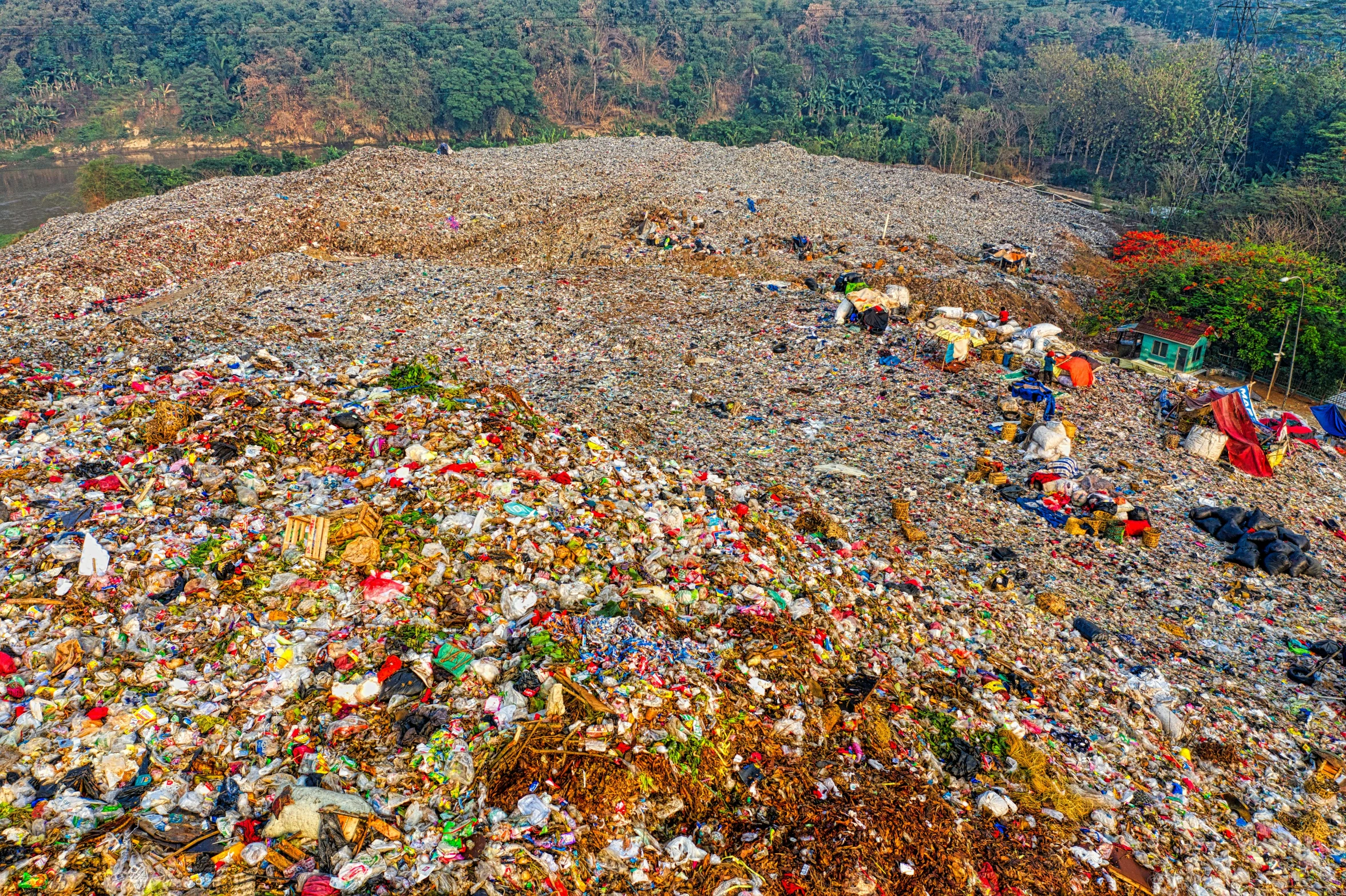 a large pile of garbage next to a river, by Daniel Lieske, pexels, “ aerial view of a mountain, shan shui, 💋 💄 👠 👗, panorama