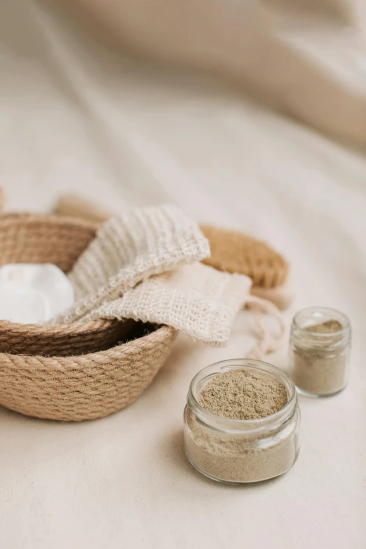 a couple of bowls sitting on top of a bed, a still life, by Eden Box, trending on pexels, renaissance, sand color, face mask, apothecary, detailed product shot