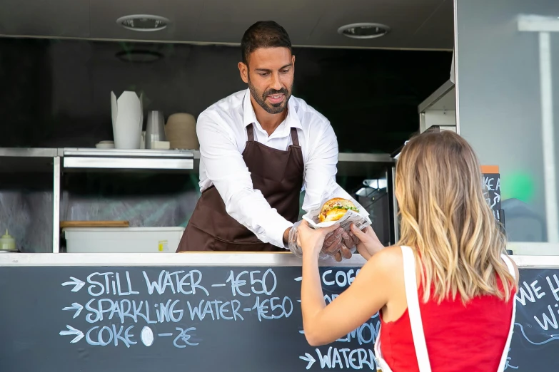 a woman taking a picture of a man at a food truck, by Lee Loughridge, pexels contest winner, ( waitress ) girl, aussie baristas, tv show still, background : diego fazio