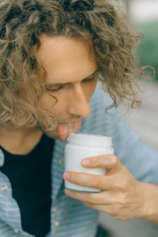 a man with long curly hair drinking out of a cup, trending on pexels, white, organic detail, smol, smelling good