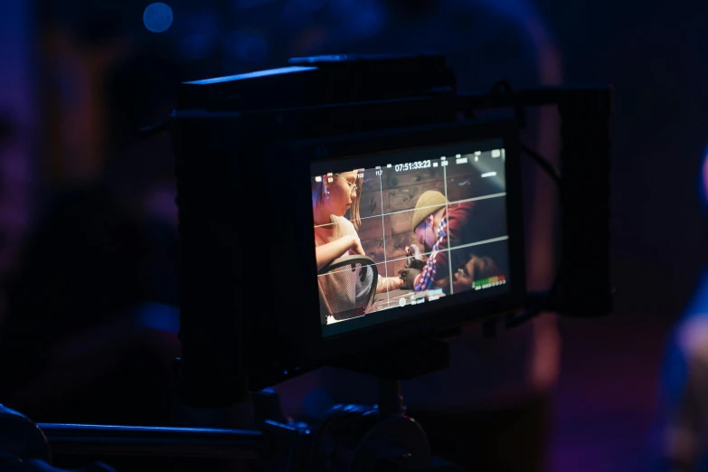 a close up of a video camera on a tripod, video art, on a stage, pc screen image, sony a 7 s, looking across the shoulder