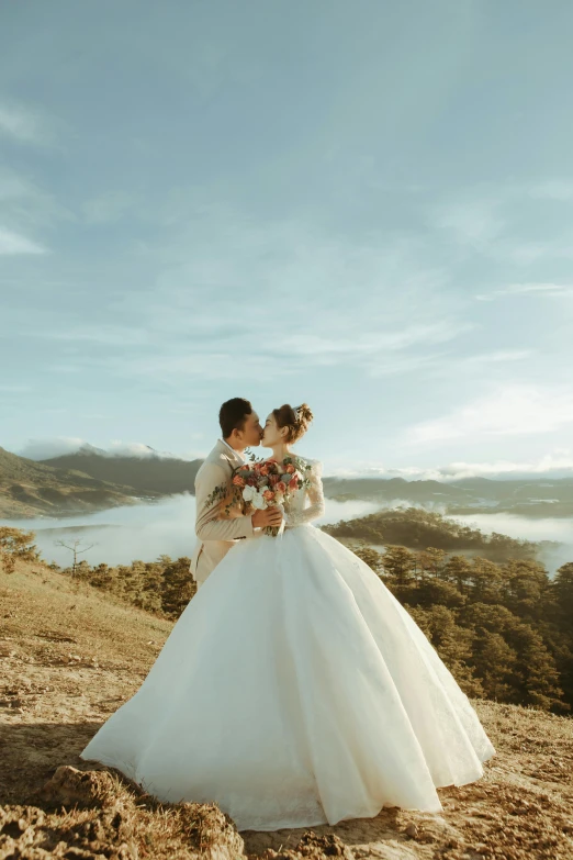 a bride and groom kissing on top of a mountain, pexels contest winner, romanticism, philippines, sunny day time, wide angle”, color”