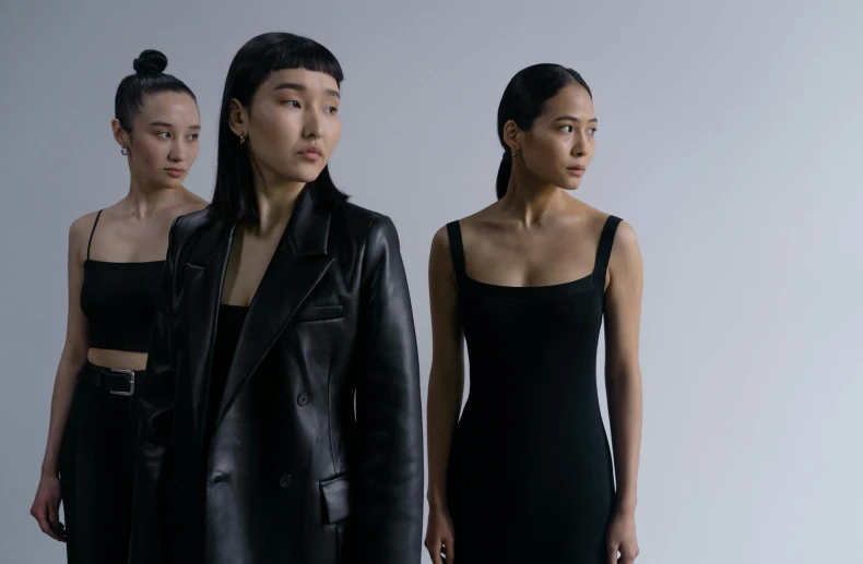 a group of women standing next to each other, inspired by Vanessa Beecroft, trending on pexels, realism, young asian woman, black leather slim clothes, [ theatrical ], wearing futuristic clothing