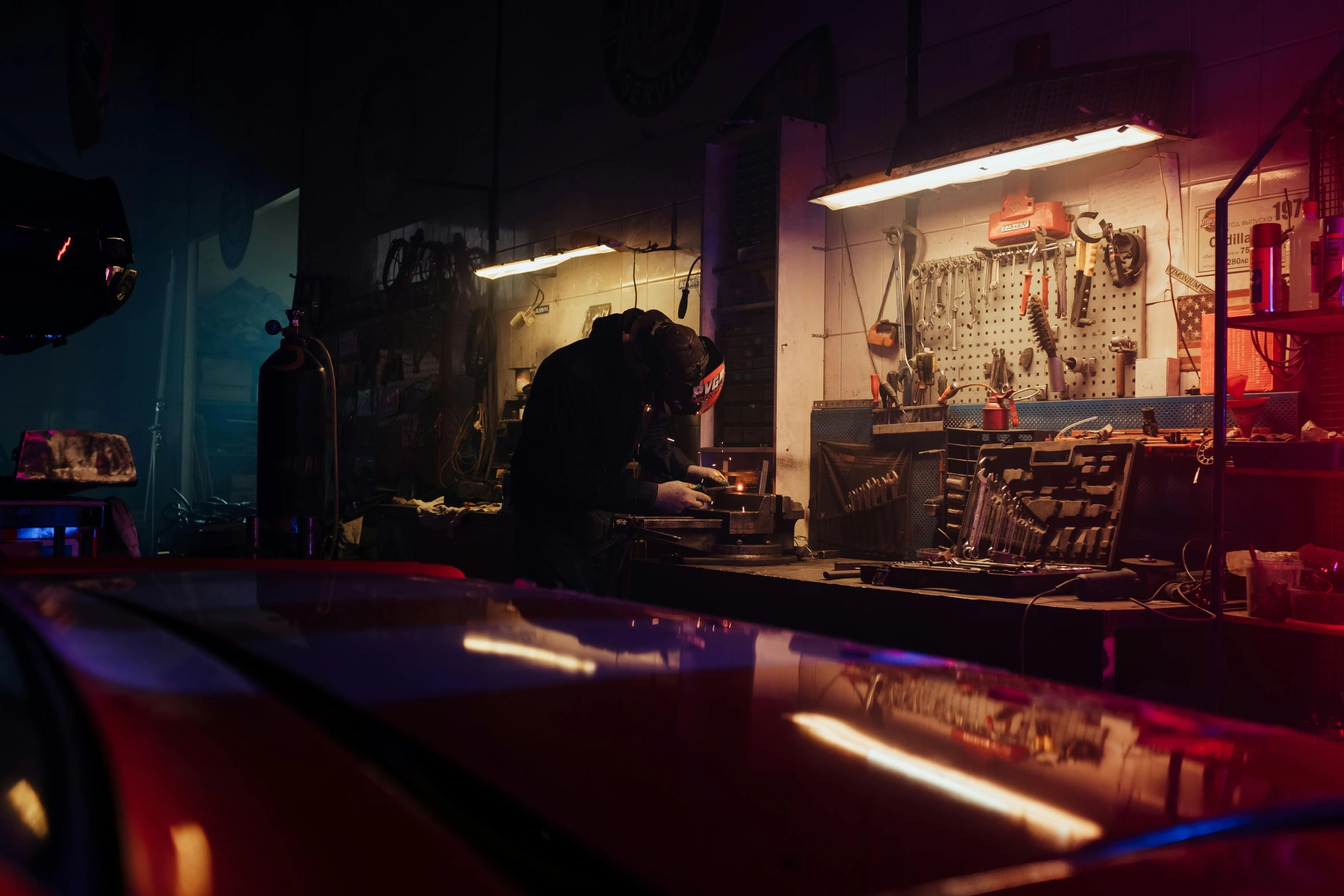 a man working on a car in a garage, inspired by Elsa Bleda, profile picture 1024px, nightlife, album, chemical woekshop