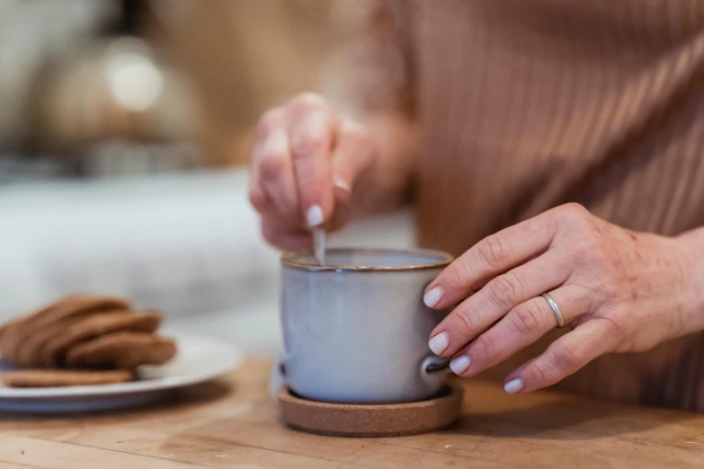 a close up of a person holding a cup of coffee, inspired by Richmond Barthé, white clay, frying nails, cosy atmosphere, grey