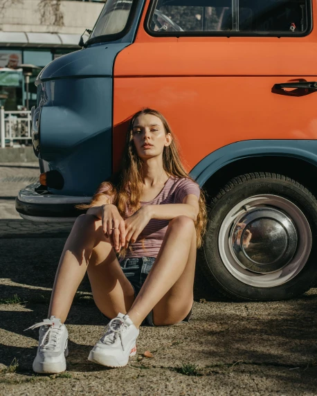 a woman sitting on the ground next to a van, pexels contest winner, queer woman, wearing shorts, in retro colors, portrait featured on unsplash