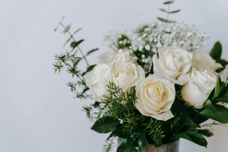 a vase filled with white roses and greenery, trending on unsplash, white freckles, white and silver, middle close up composition, various styles
