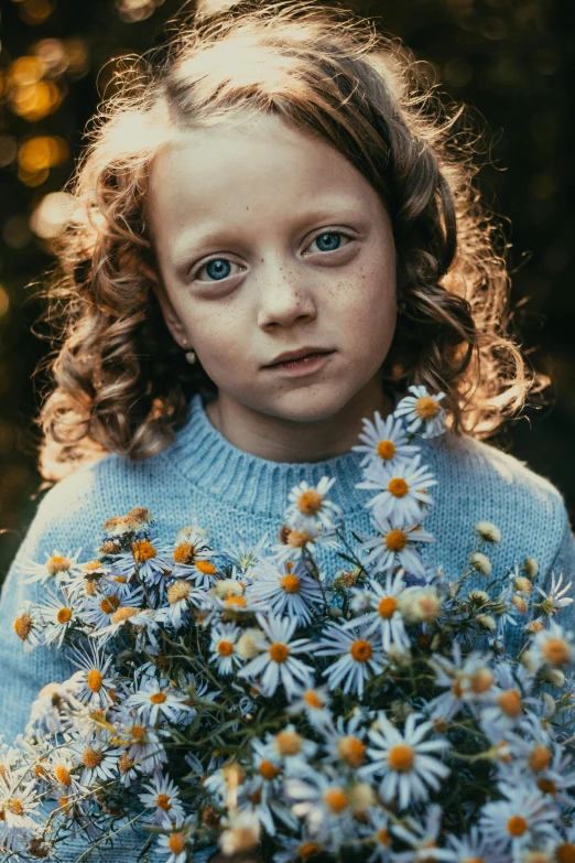 a little girl holding a bunch of daisies, by irakli nadar, pexels contest winner, fine art, blue sweater, intense stare, medium format. soft light, the girl made out of flowers