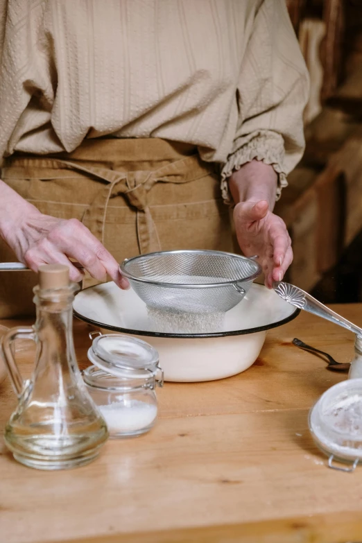 a close up of a person preparing food on a table, inspired by Wilhelm Hammershøi, yeast, straining, adventure, white