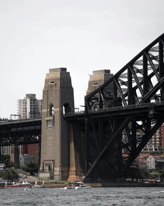 a large bridge over a body of water, inspired by Sydney Carline, pexels contest winner, two organic looking towers, outram, grey, buttresses