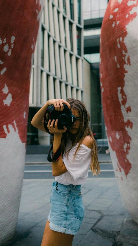 a woman taking a picture of a giant vase, inspired by Elsa Bleda, pexels contest winner, looking at the camera, an young urban explorer woman, medium format, taking a picture