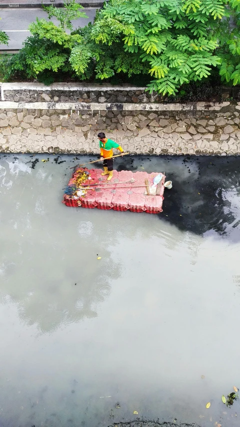 a person on a raft in a body of water, by Basuki Abdullah, clean streets, cleaned up, overhead, south jakarta