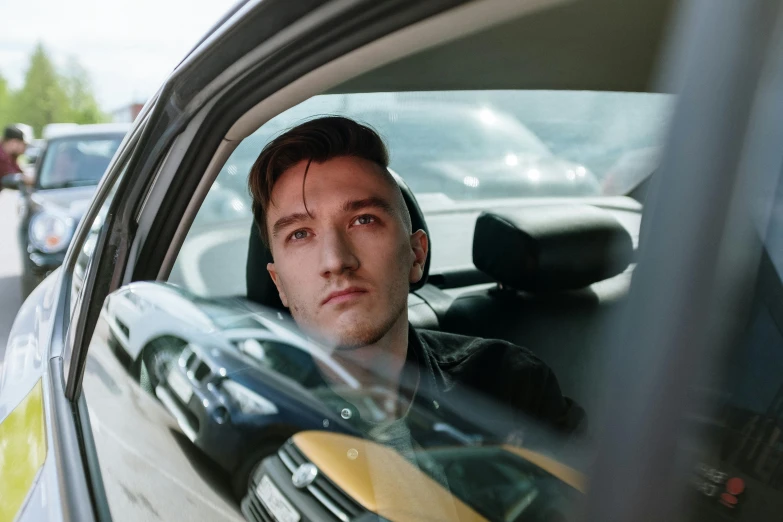 a man sitting in the driver's seat of a car, an album cover, pexels contest winner, photorealism, mark edward fischbach, a handsome, rainny, flume