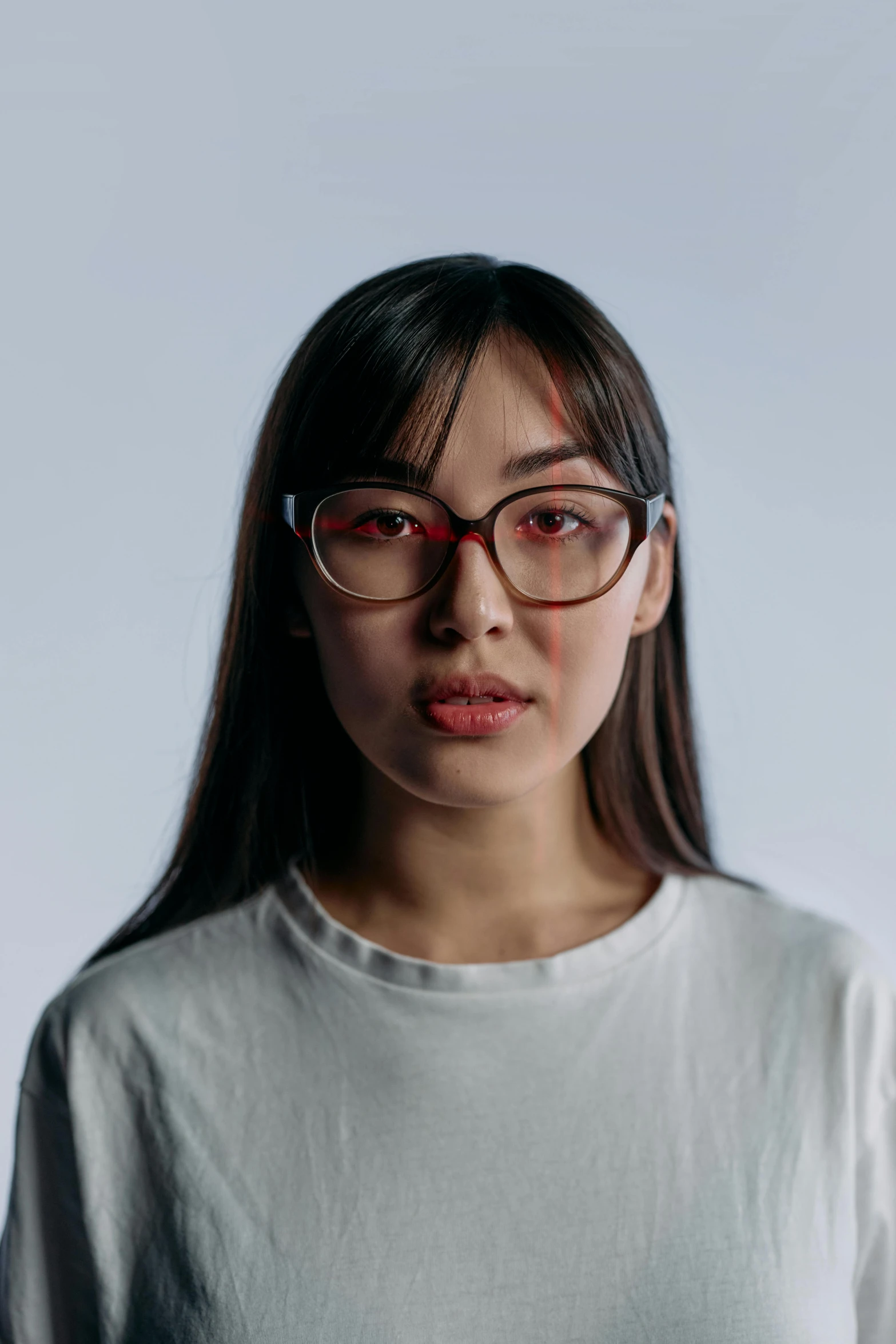 a woman wearing glasses and a white shirt, inspired by Ruth Jên, featured on reddit, with red haze, looking straight to camera, pokimane, set against a white background