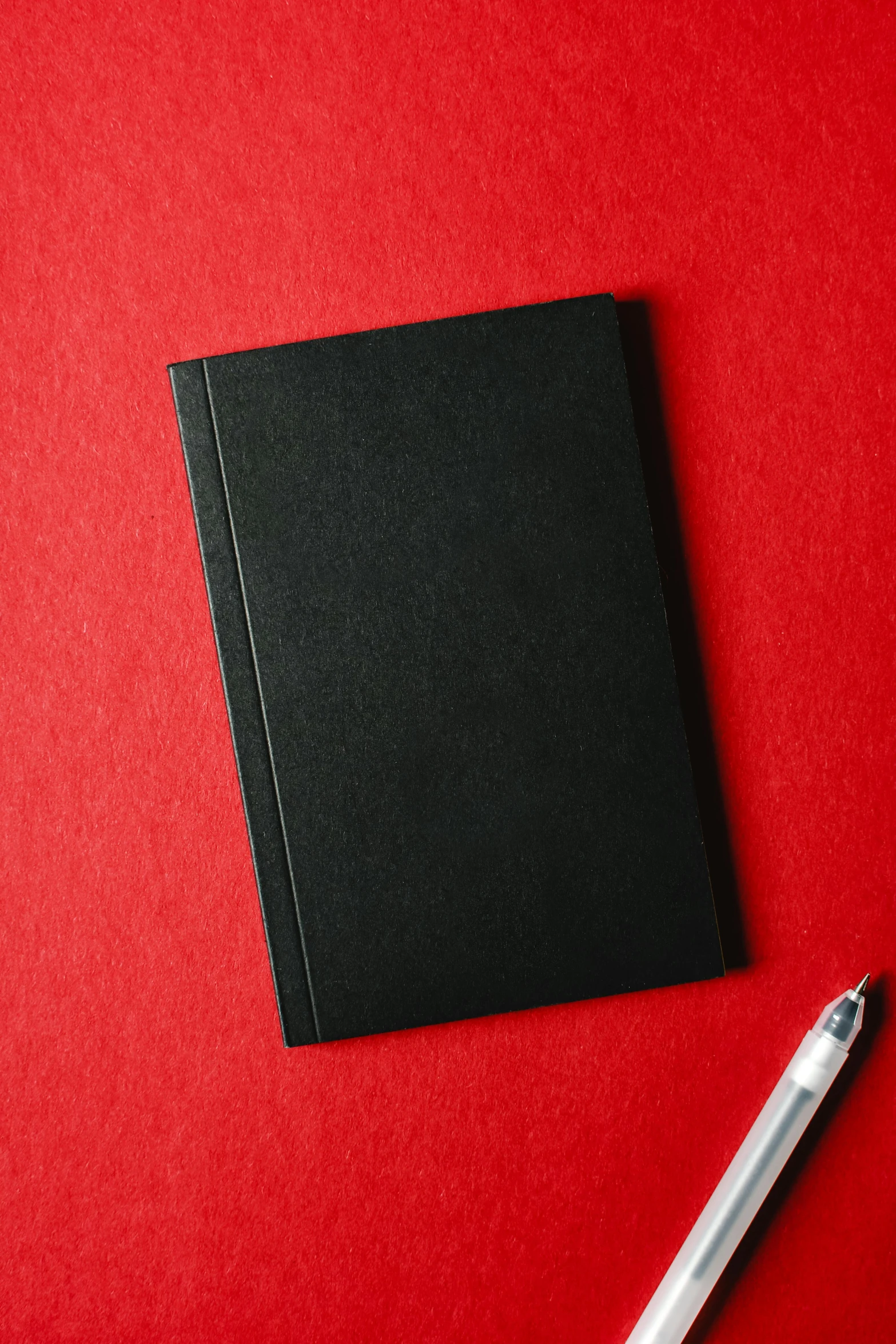 a notebook and a pen on a red background, an album cover, by James Morris, unsplash, black canvas, 15081959 21121991 01012000 4k, cosplay journal cover, hero shot