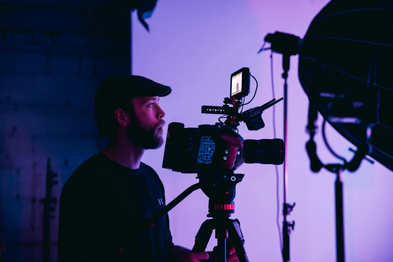 a man that is standing in front of a camera, a picture, purple scene lighting, cinestill colour cinematography, instagram post, red camera