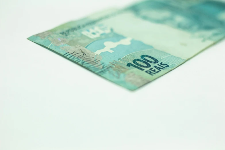 a close up of a bank note on a table, pexels contest winner, hyperrealism, with a white background, brazil, blue - green tones, 1 0 0