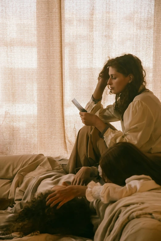 a group of people sitting on top of a bed, pexels contest winner, romanticism, village girl reading a book, film still from movie dune-2021, woman holding another woman, old testament