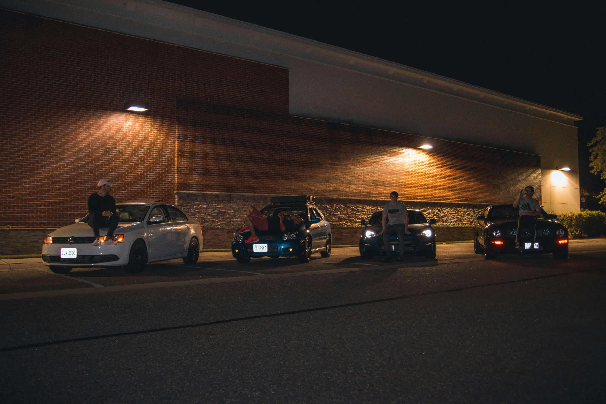 a group of cars parked in front of a building, by Ryan Pancoast, people at night, exiting store, profile image, camaraderie