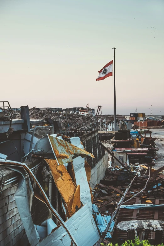 a boat sitting on top of a beach next to a flag, by Elsa Bleda, trending on unsplash, auto-destructive art, buildings collapsed, ruined gas station and cars, photo of monstrous tornado, peru