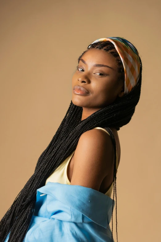 a woman with long black hair wearing a blue dress, an album cover, inspired by Ras Akyem, trending on pexels, cloth head wrap, at a fashion shoot, woman with braided brown hair, pastel'