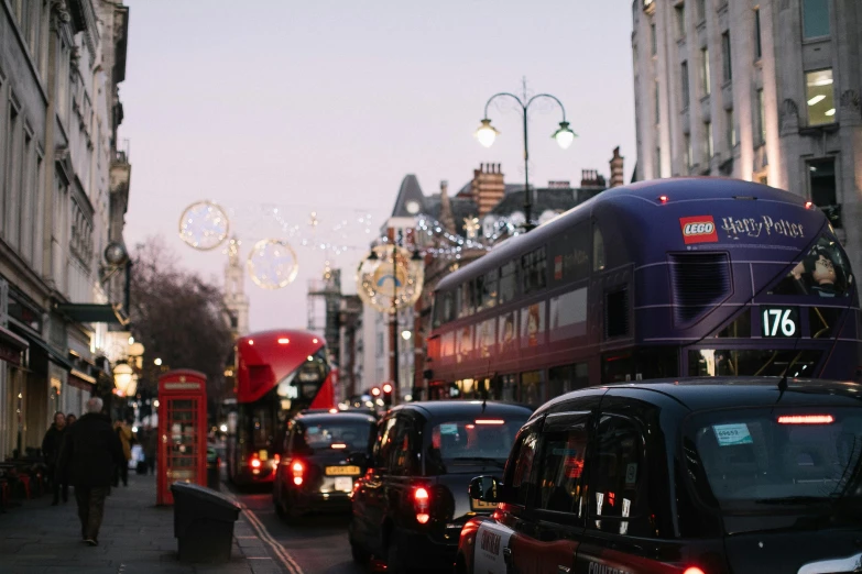 a street filled with lots of traffic next to tall buildings, by Nick Fudge, pexels contest winner, happening, festive, ( ( ( buses, square, thumbnail