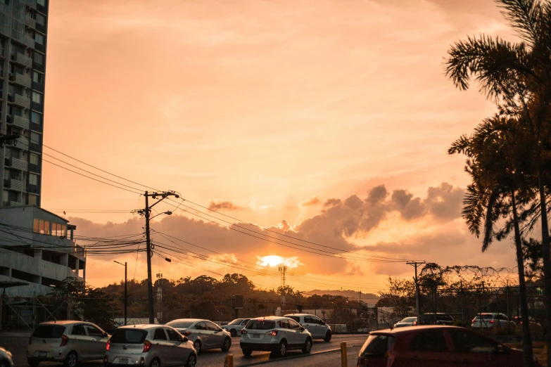 a street filled with lots of traffic next to tall buildings, by Carey Morris, pexels contest winner, nice sunset, in a suburb, suns, manly