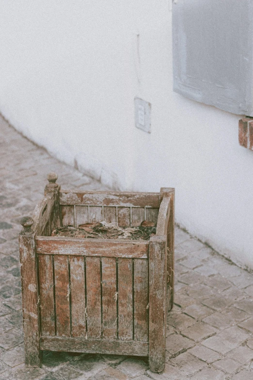 a wooden crate sitting on the side of a building, trending on unsplash, arte povera, in a village street, photogrammetry, low quality photo, profile image